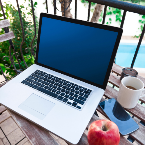 laptop on a desk with an apple